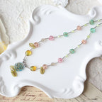 Colorful beaded necklace on a white decorative plate with a textured surface