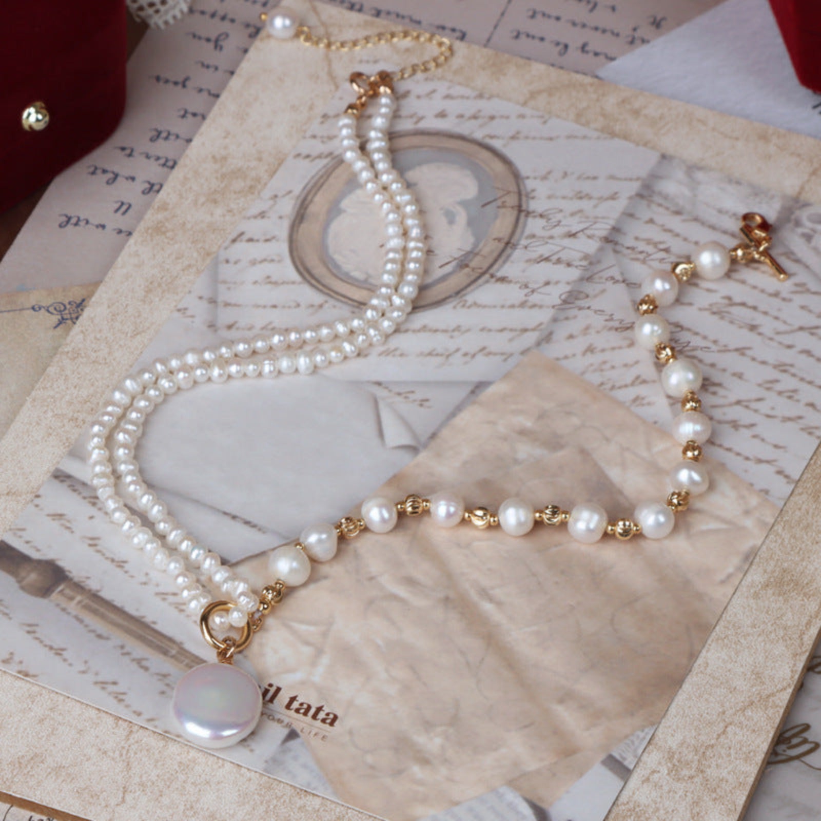 Pearl necklace with gold accents on a textured surface