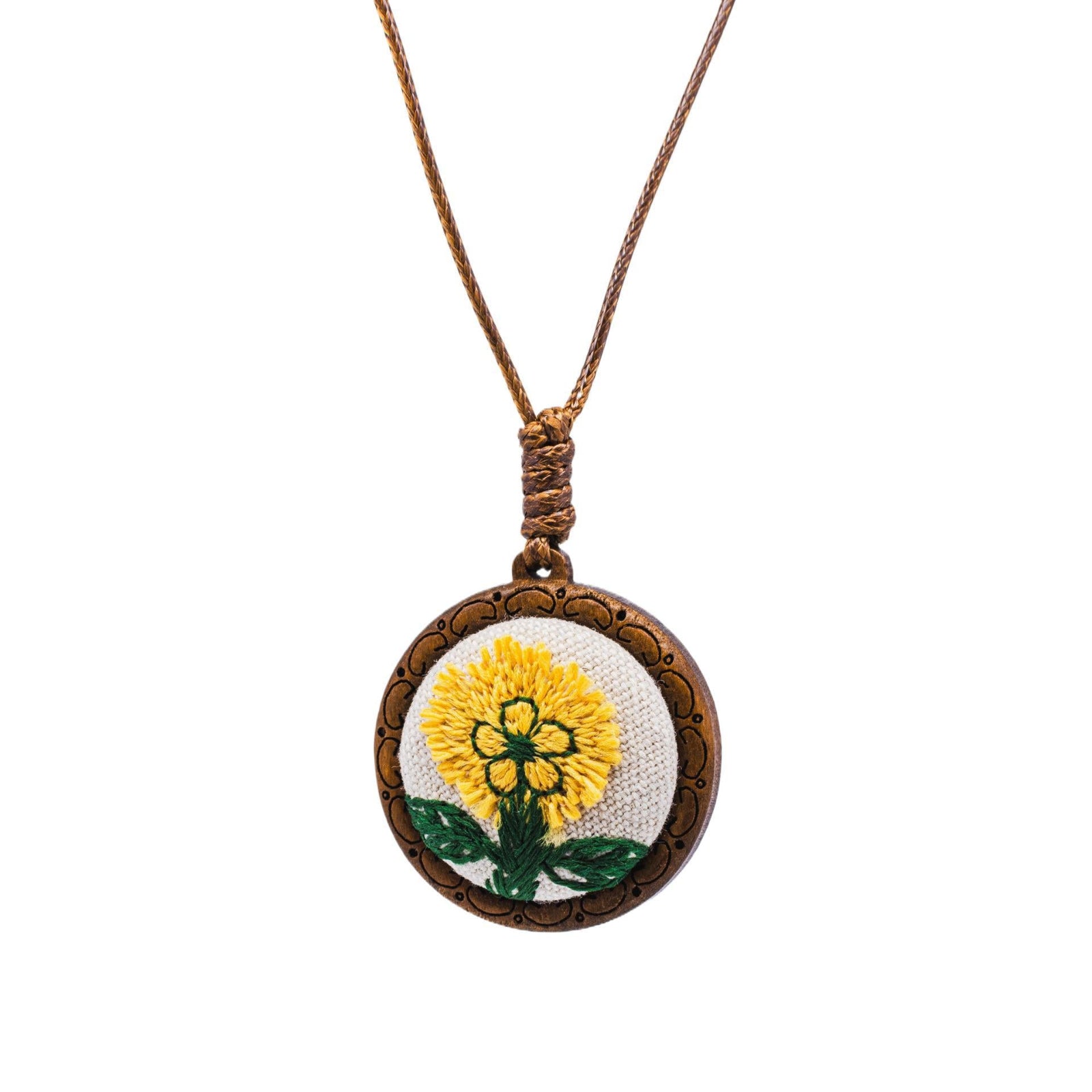 Necklace with a round pendant featuring a embroidered yellow flower on a white background