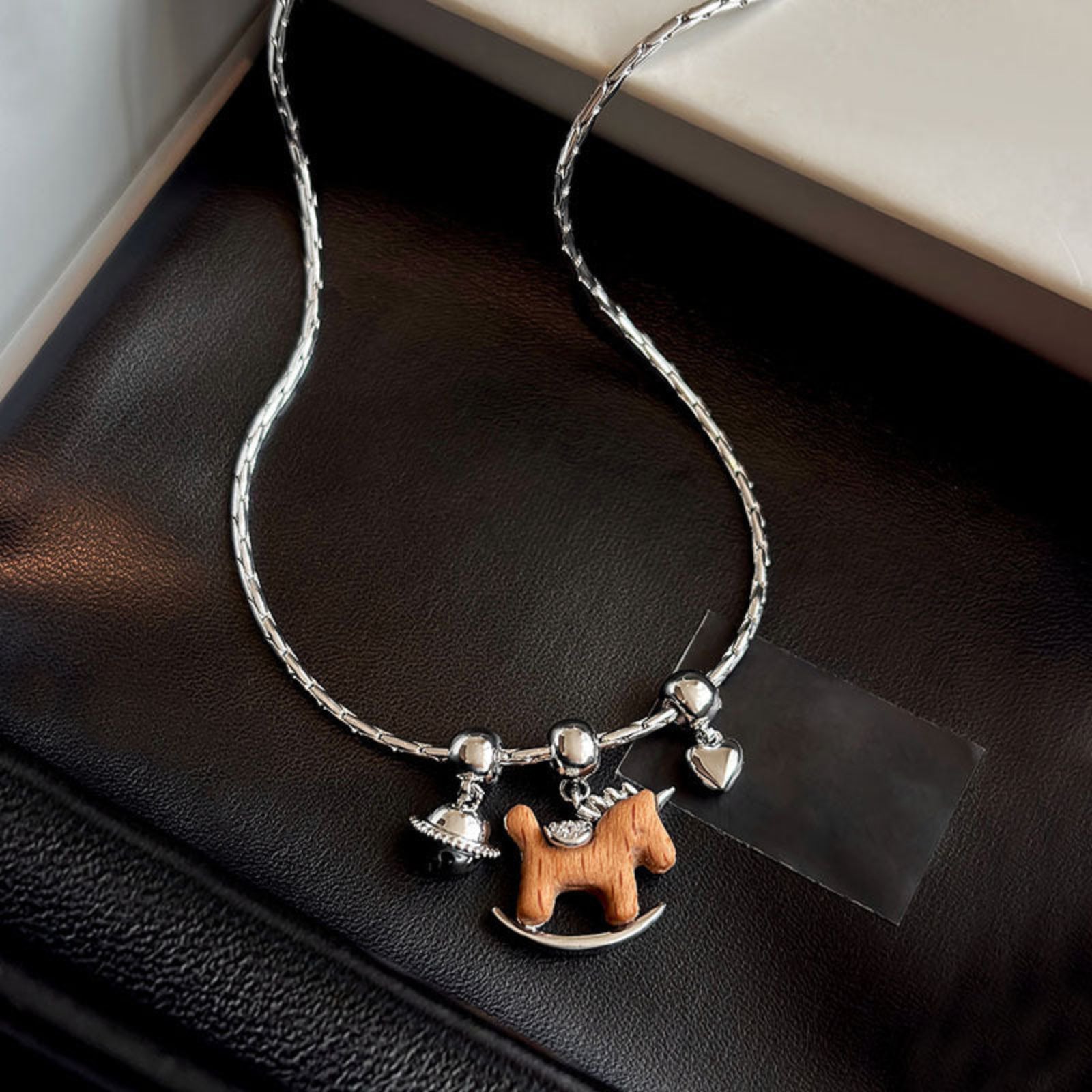 Necklace with horse charm on a black surface