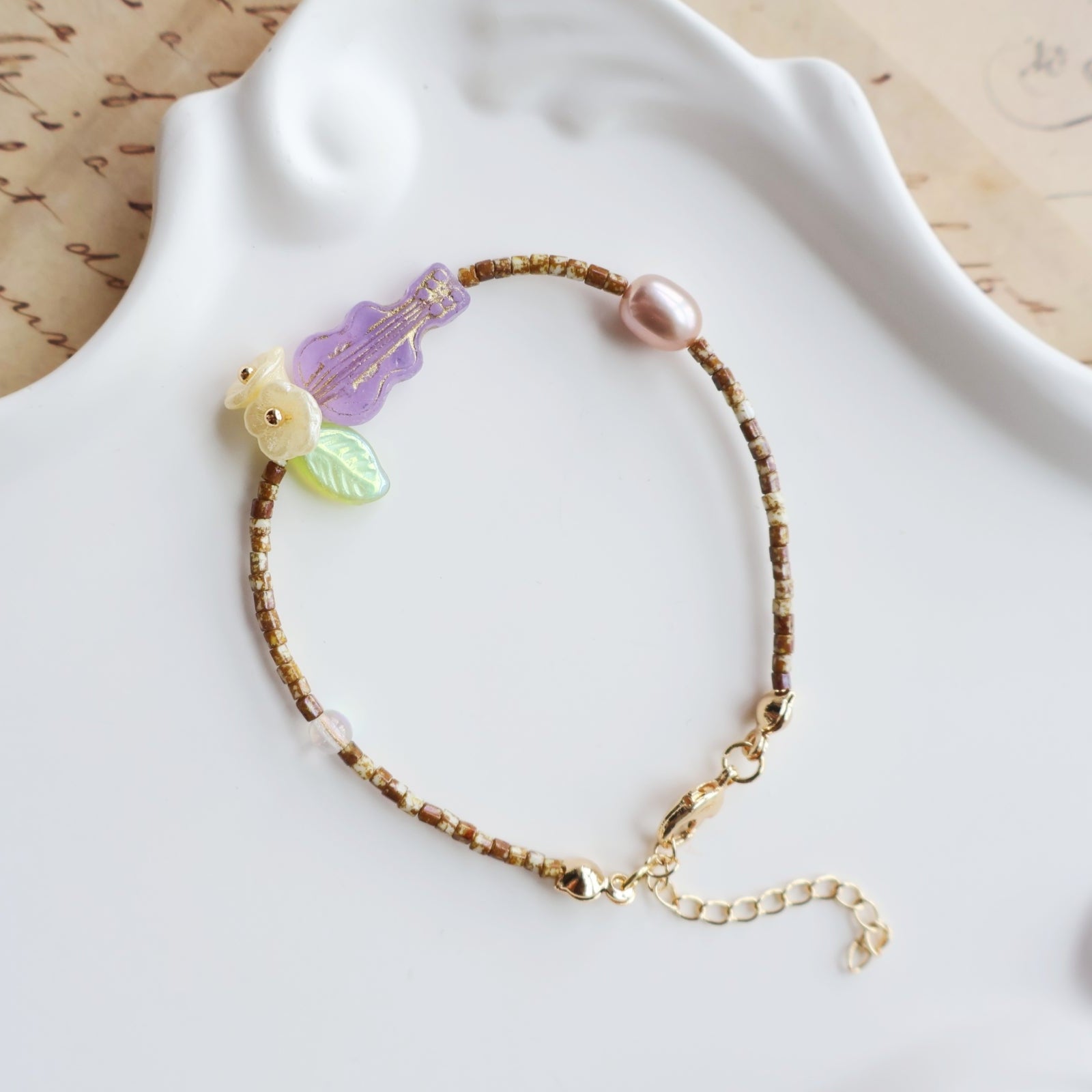 Bracelet with floral and butterfly charms on a white surface