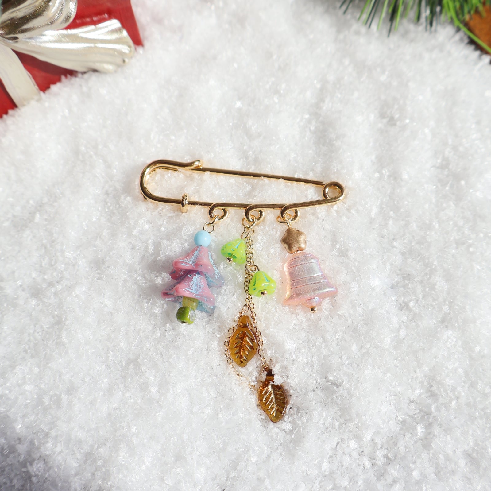 Decorative brooch with colorful charms on a snowy background