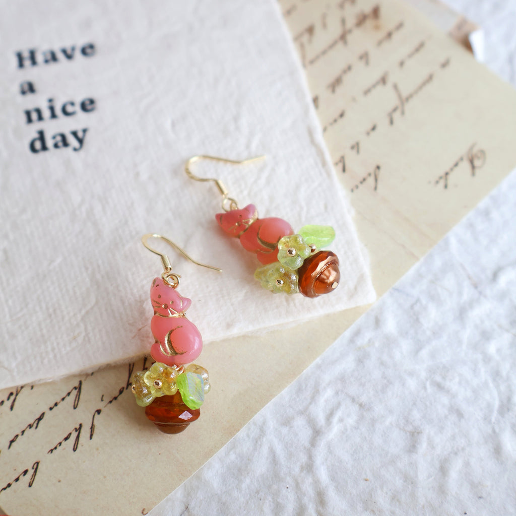 Pair of colorful beaded earrings on a textured paper background