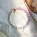 Beaded bracelet with pink and white pearls on a light fabric background