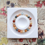 Colorful beaded bracelet on a white dish with a floral and text background