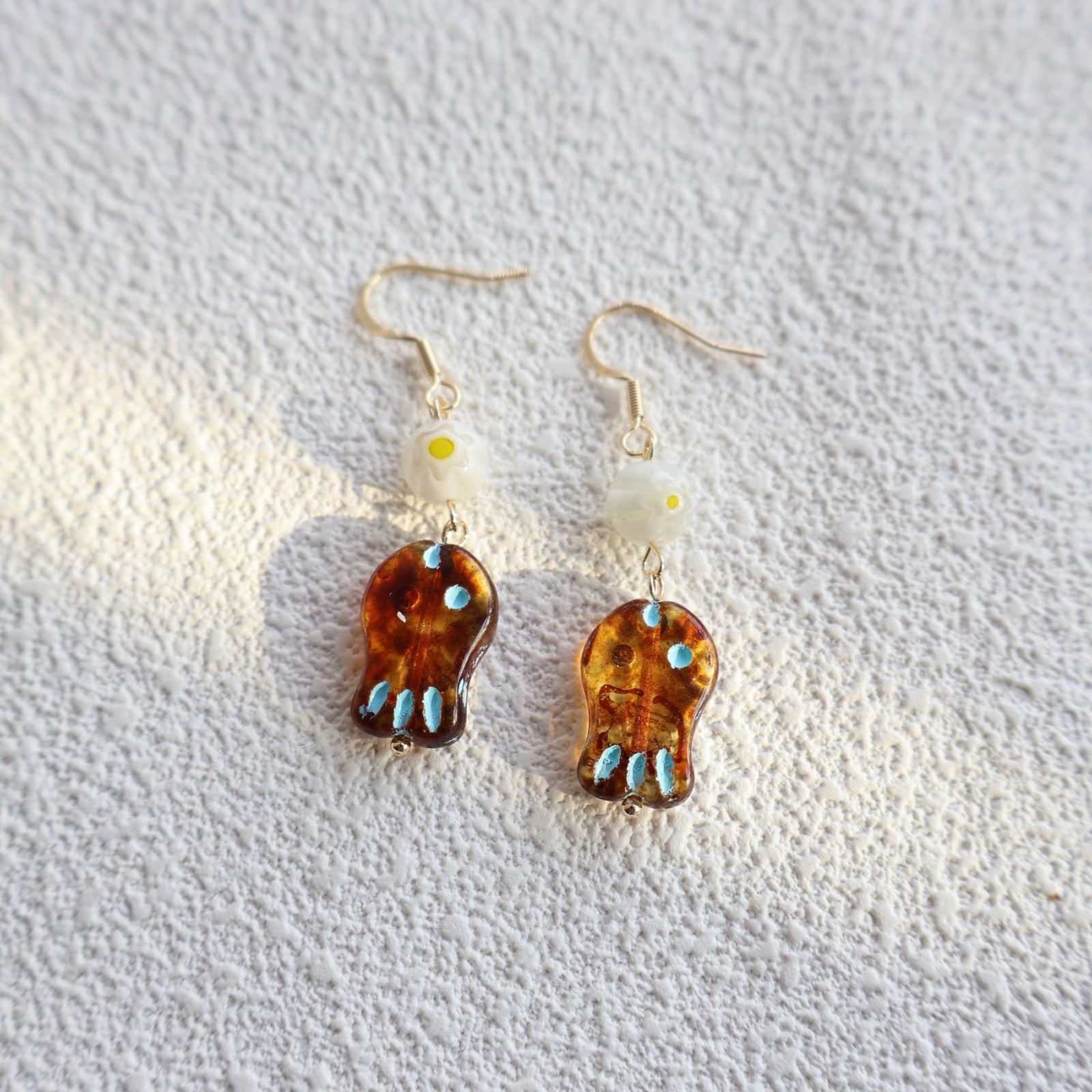 Pair of earrings with tortoiseshell design on a textured white background