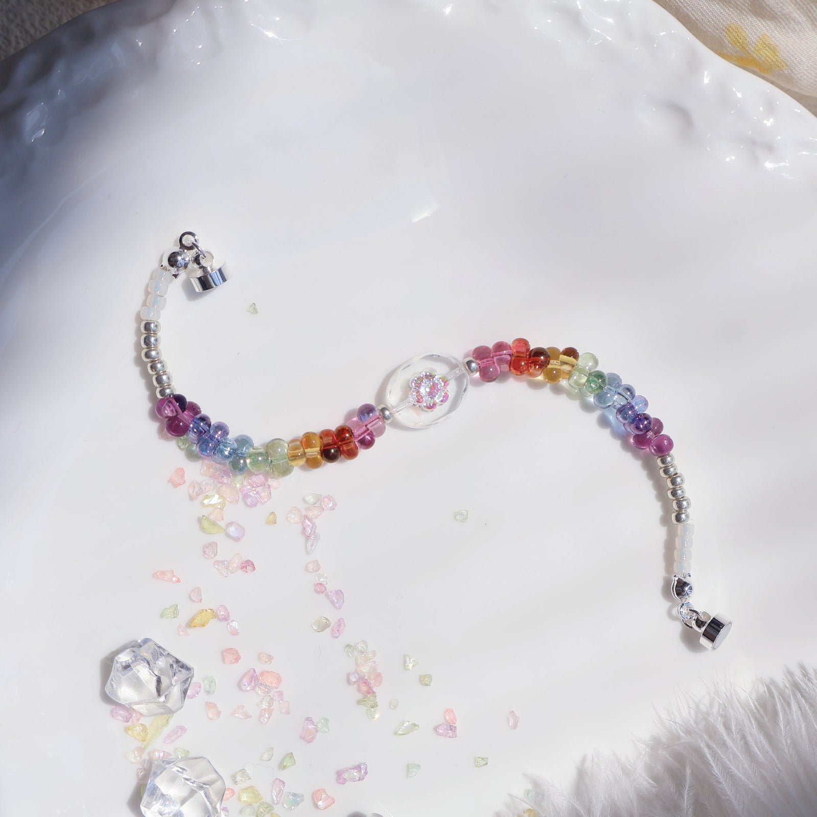 Colorful beaded necklace on a white surface with decorative elements