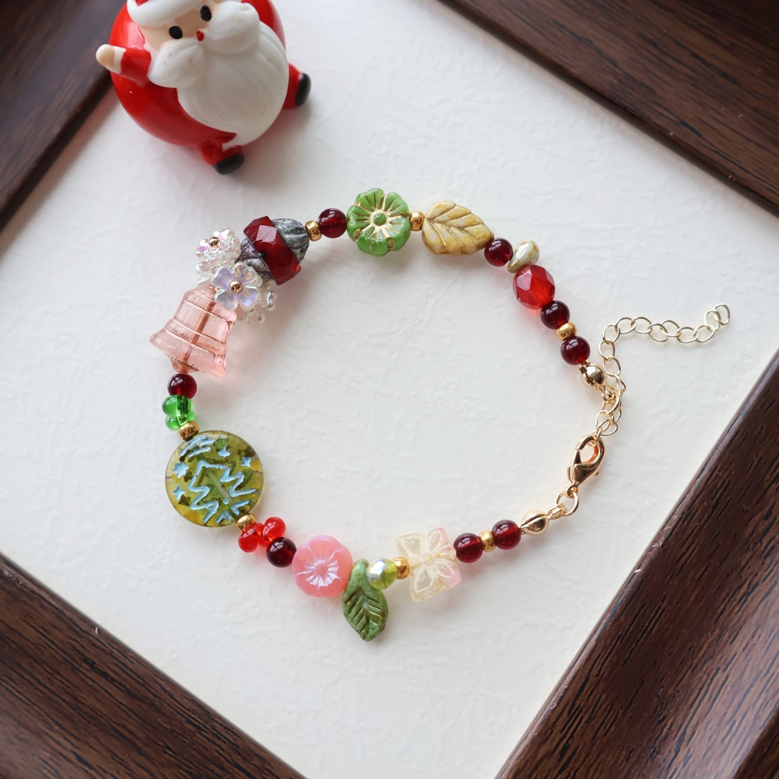 Colorful beaded bracelet on a white surface with a small figurine in the background