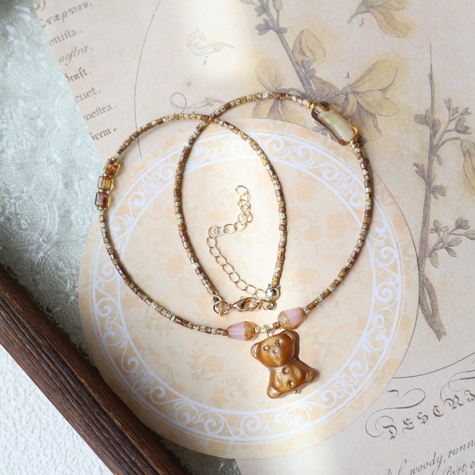 Necklace with a pendant on an ornate paper background
