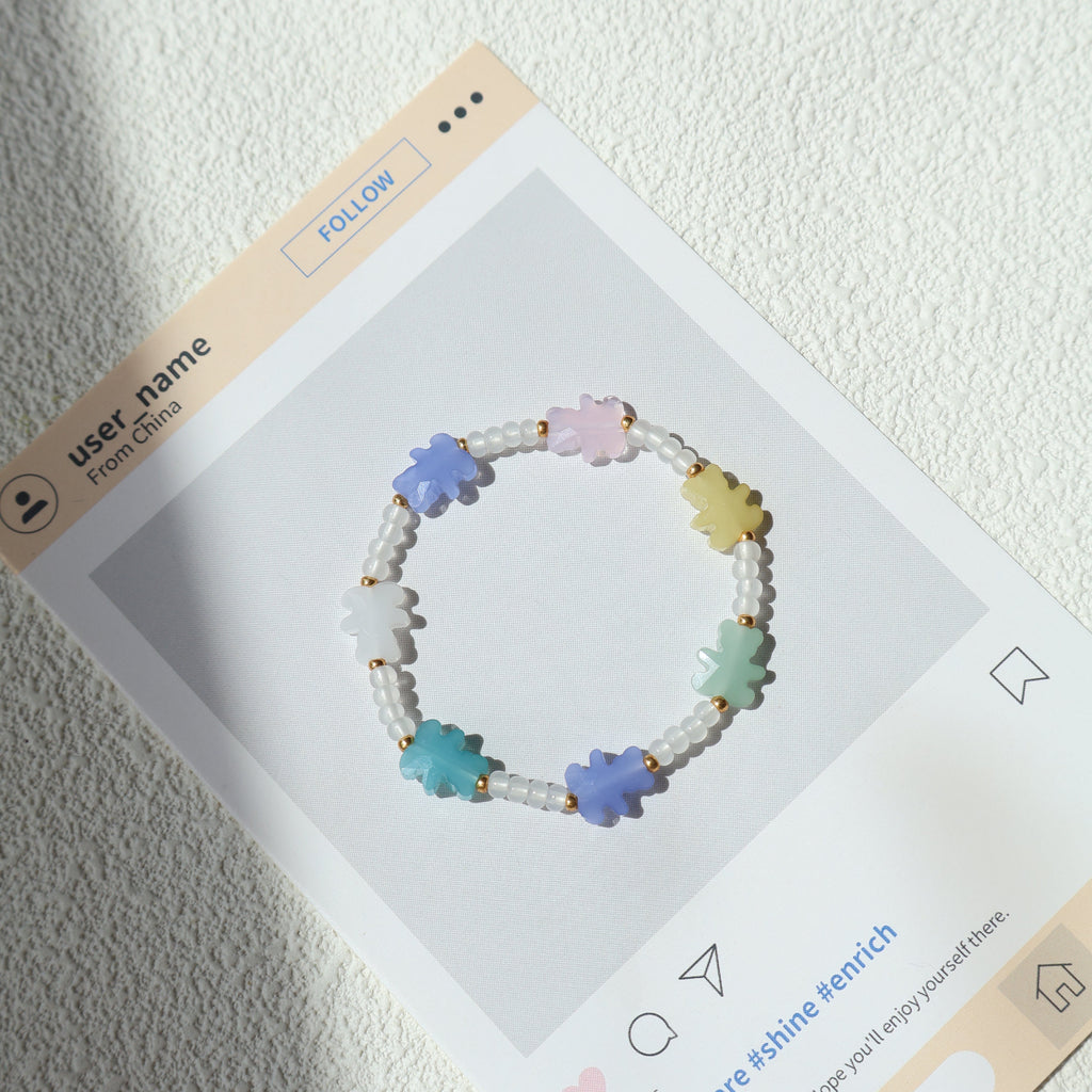 Colorful beaded bracelet on a display card with a textured white background
