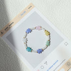 Colorful beaded bracelet on a display card with a textured white background