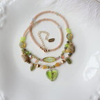 Two beaded necklaces on a textured white surface