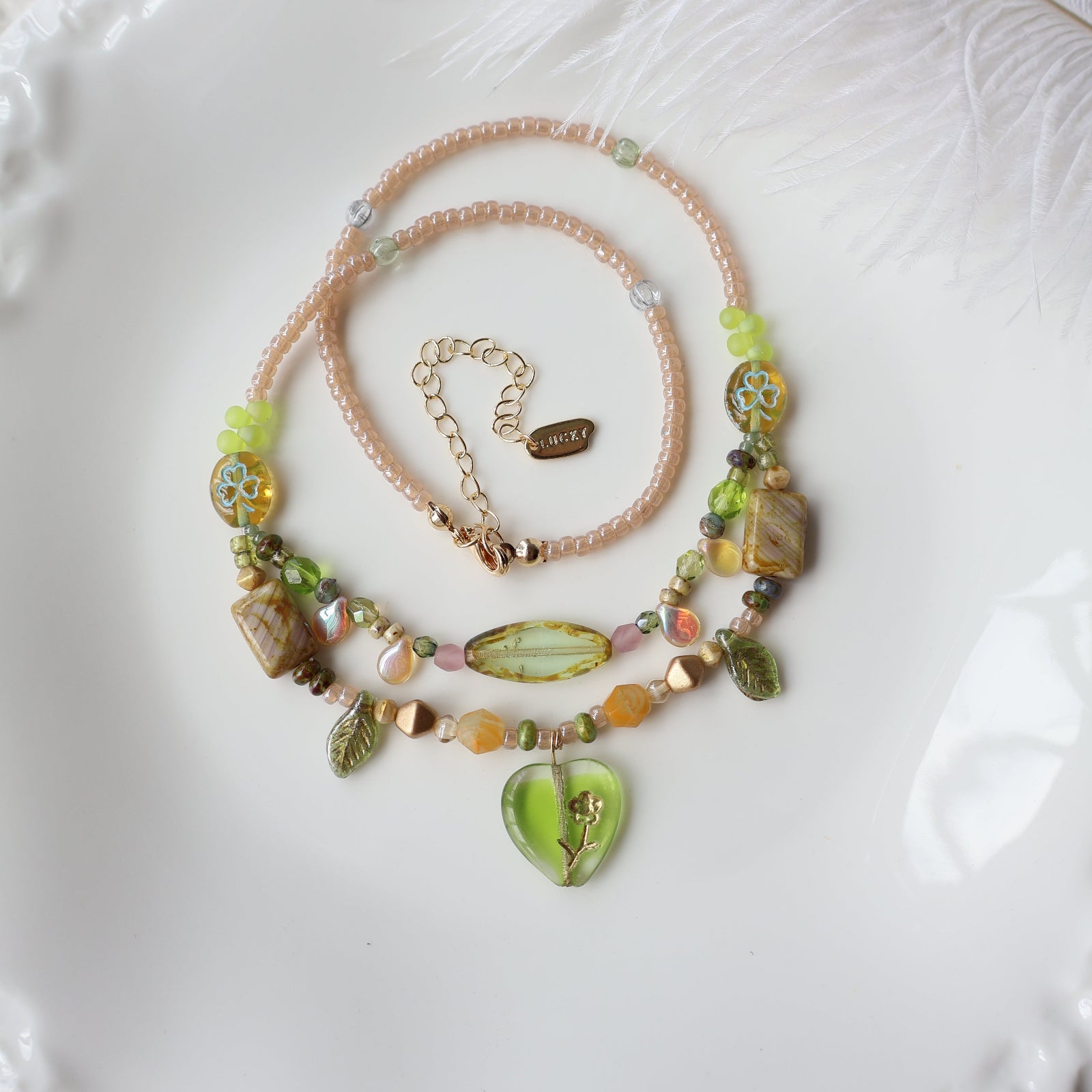 Two beaded necklaces on a textured white surface