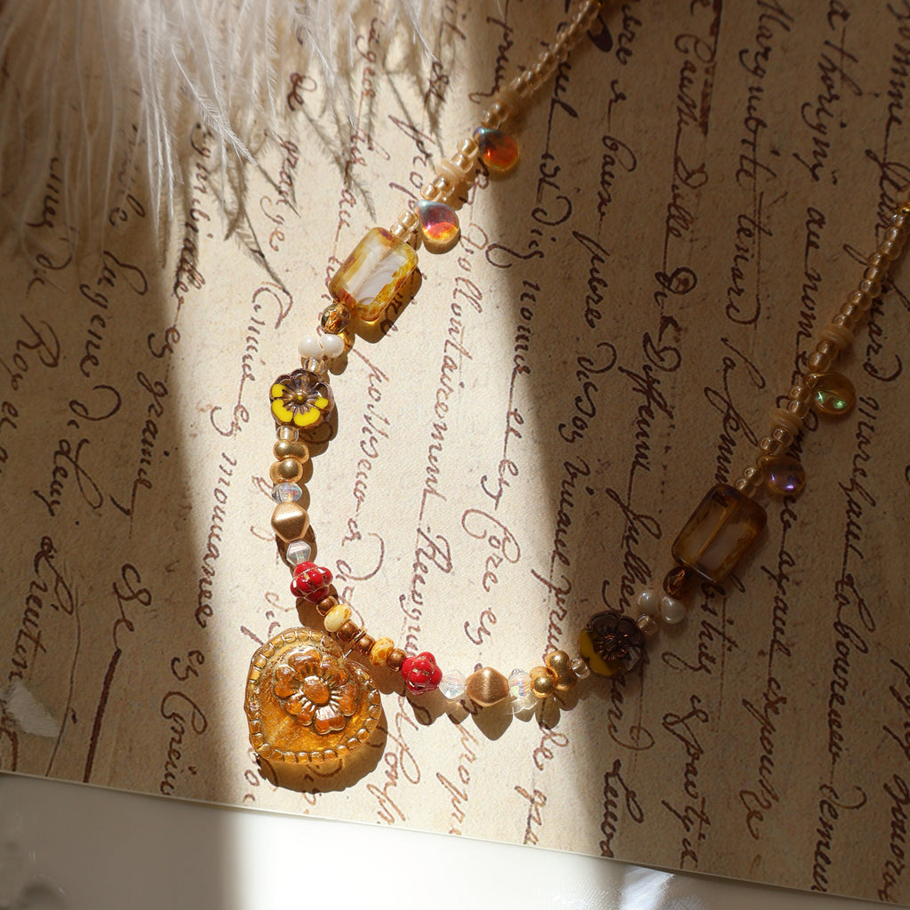 Necklace with amber and red beads on an old document