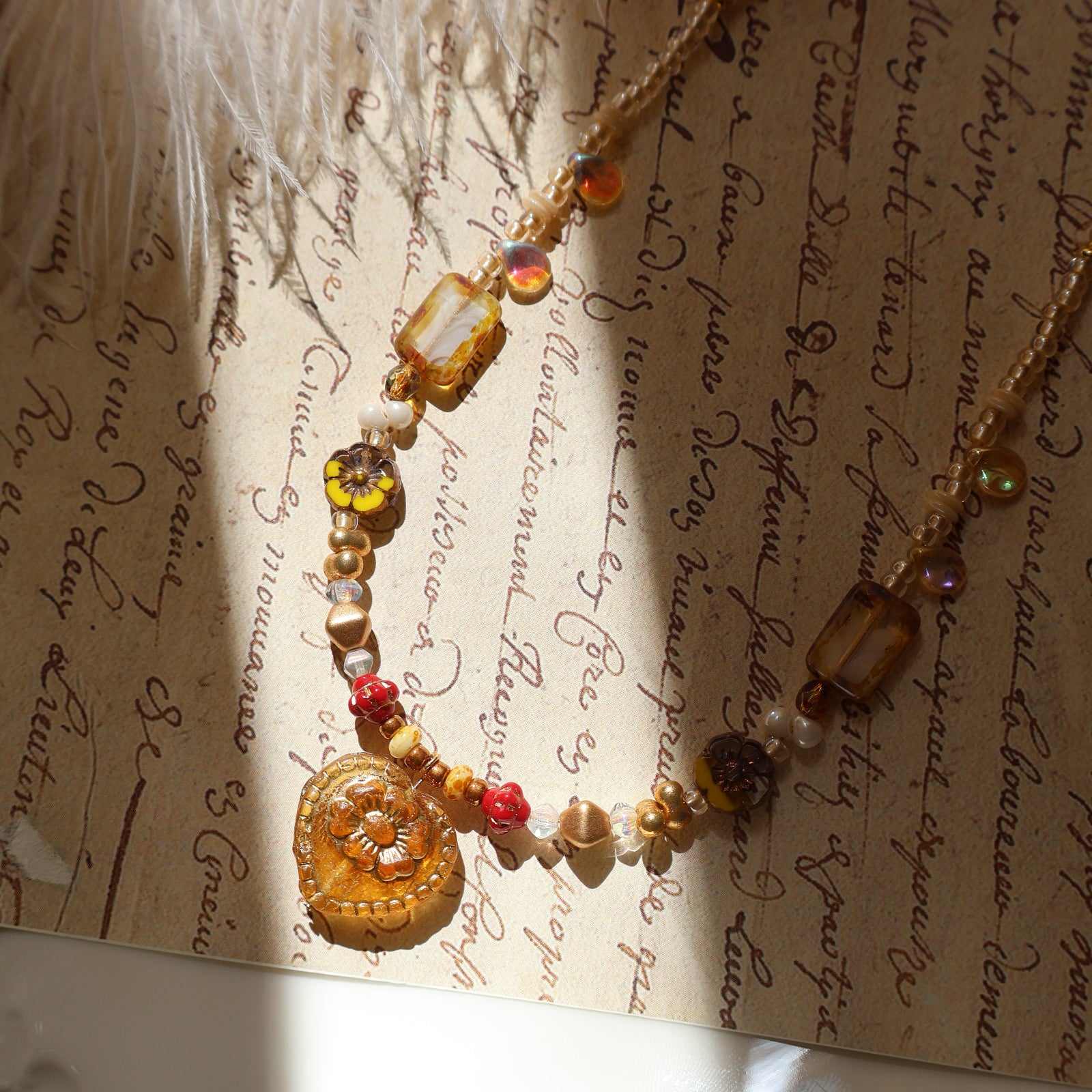 Necklace with amber and red beads on an old document