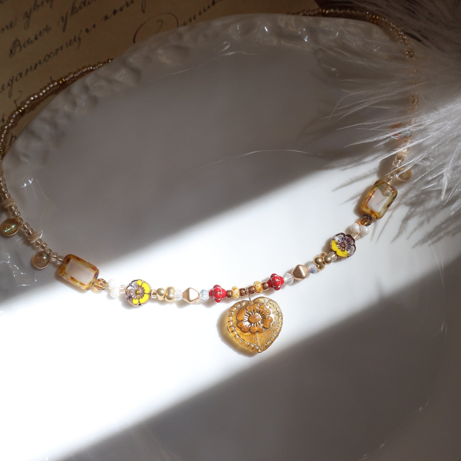 Necklace with colorful beads on a white shell and feather