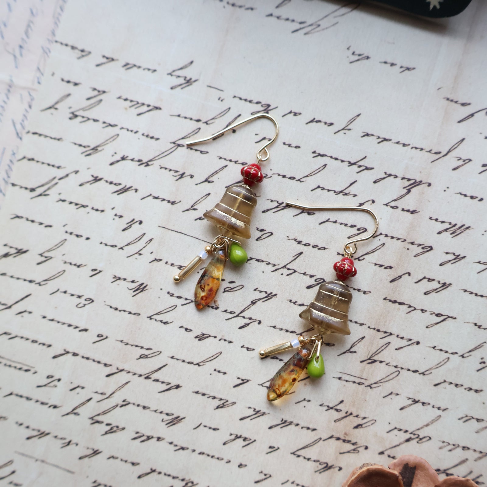 Pair of beaded earrings on a textured surface with 'Christmas' text