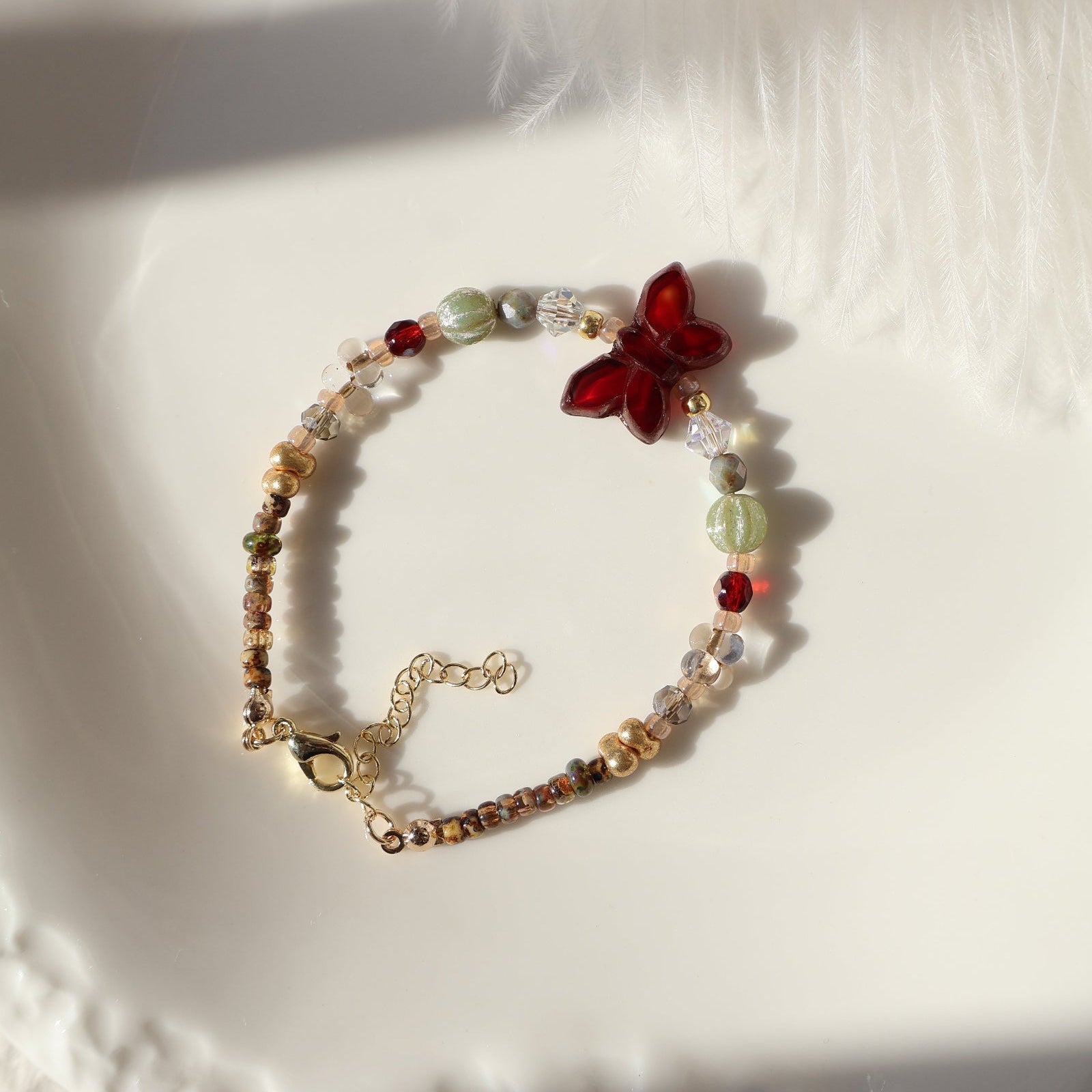 Bracelet with a butterfly charm on a white plate
