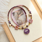 Set of beaded bracelets with decorative elements on a wooden tray.