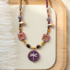 Beaded necklace with decorative elements on a wooden tray