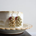Gold earrings with red stones on a white dish