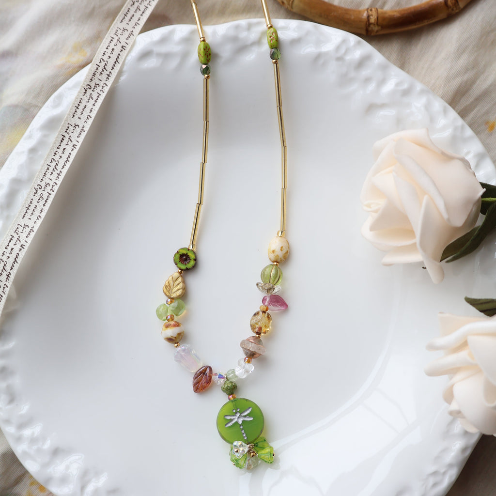 Colorful beaded bracelet on a white plate with a flower and wooden object in the background
