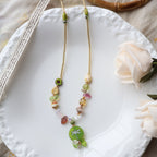Colorful beaded bracelet on a white plate with a flower and wooden object in the background