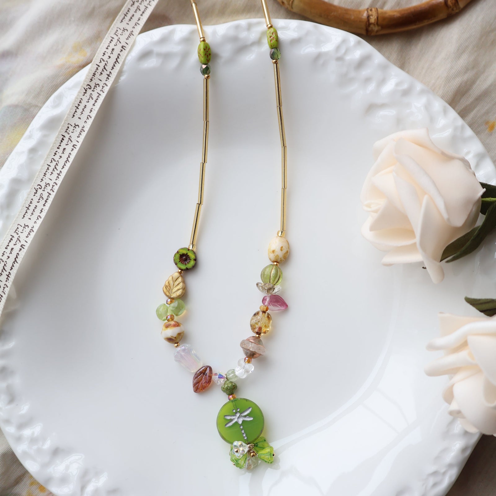 Colorful beaded bracelet on a white plate with a flower and wooden object in the background