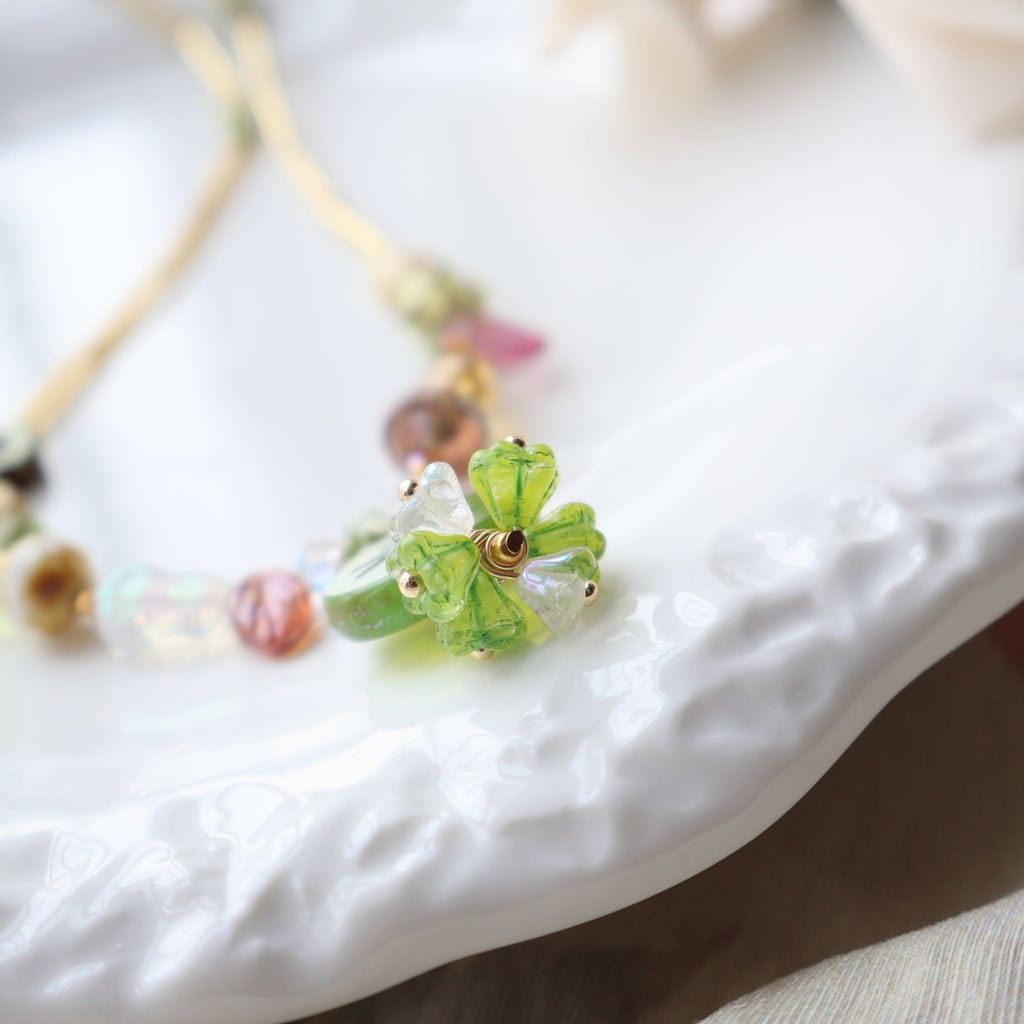 Close-up of a decorative brooch with green gemstones on a blurred background