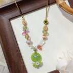 Decorative hairpin with colorful beads and a green dragonfly design in a wooden frame.