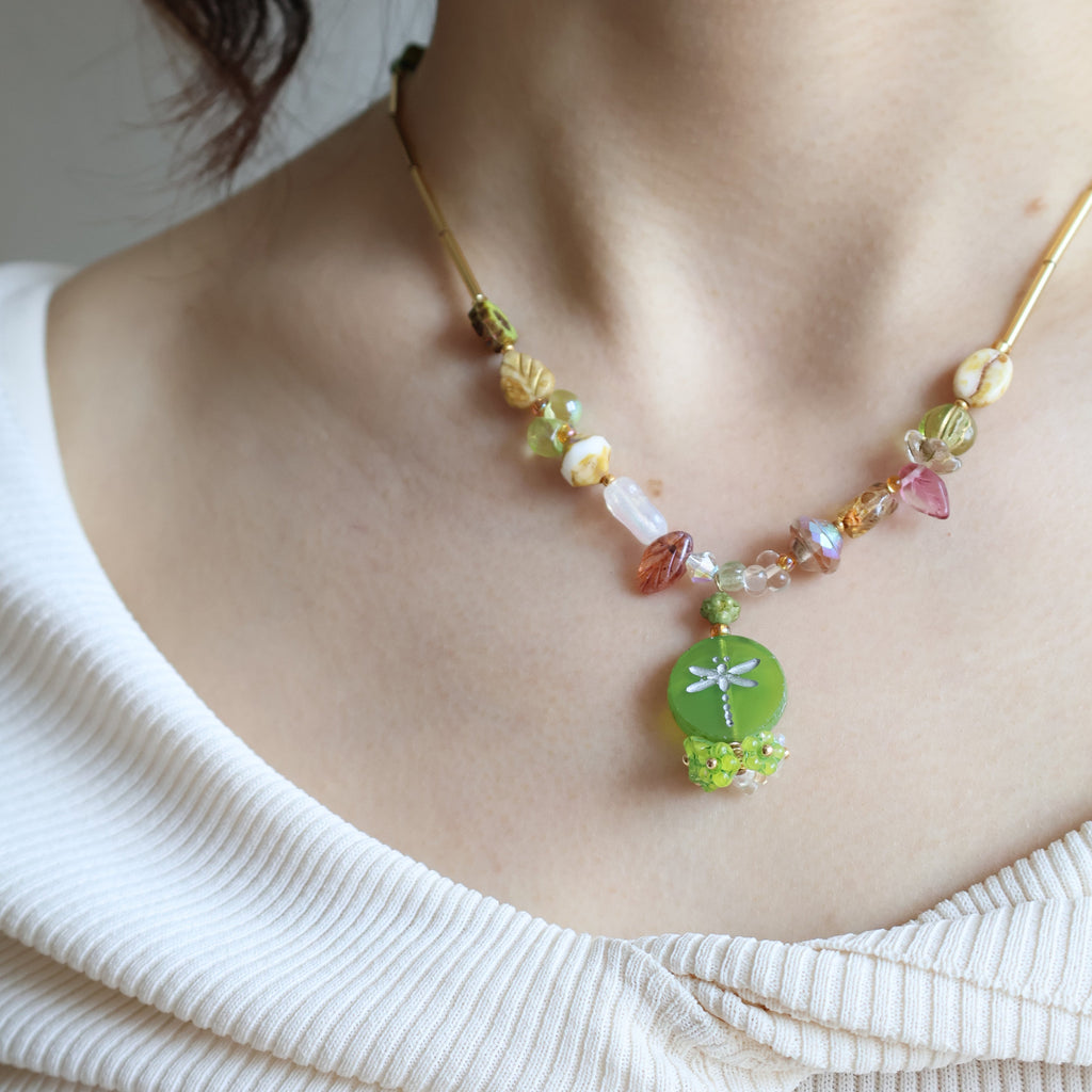 Close-up of a person wearing a colorful beaded bracelet on a plain background