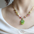 Close-up of a person wearing a colorful beaded bracelet on a plain background