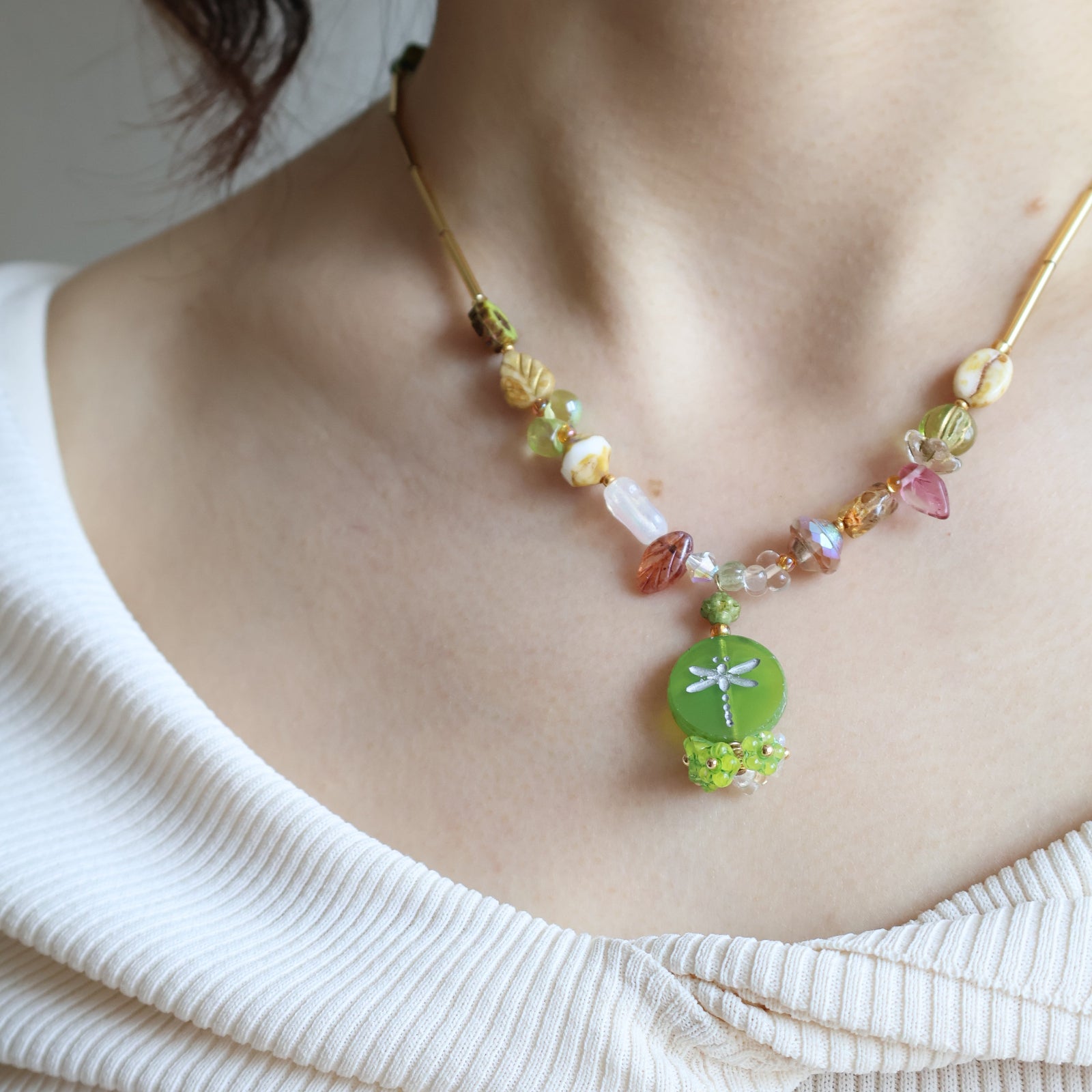 Close-up of a person wearing a colorful beaded bracelet on a plain background
