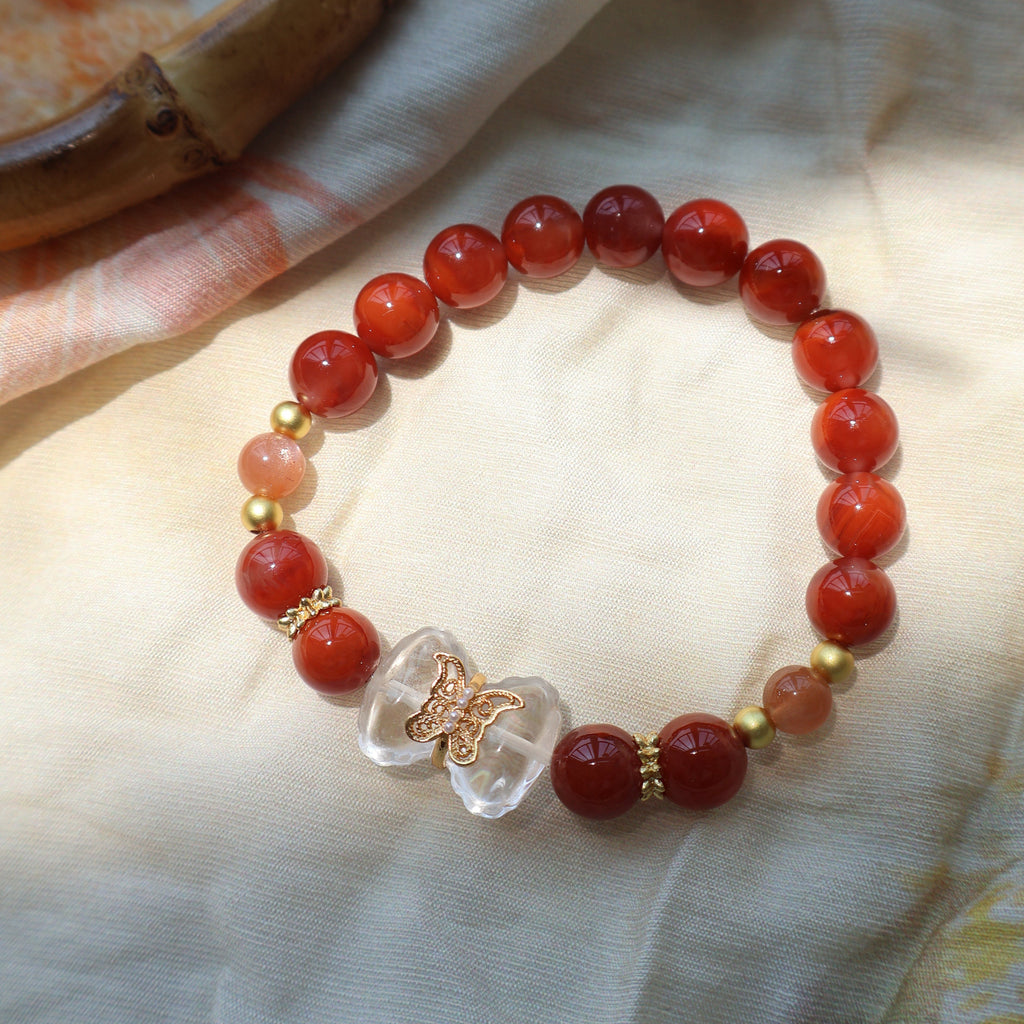 Beaded bracelet with red and clear beads on a light fabric background