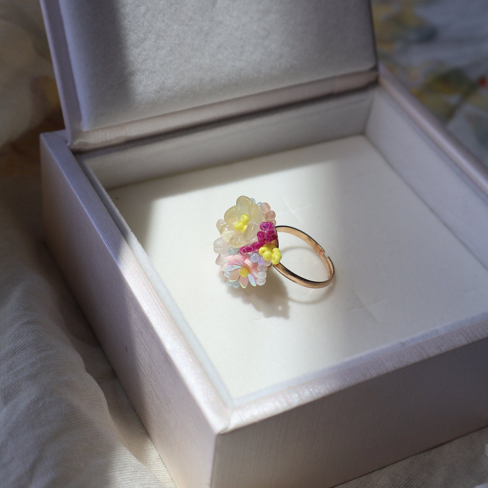 Decorative ring with colorful flowers in a jewelry box