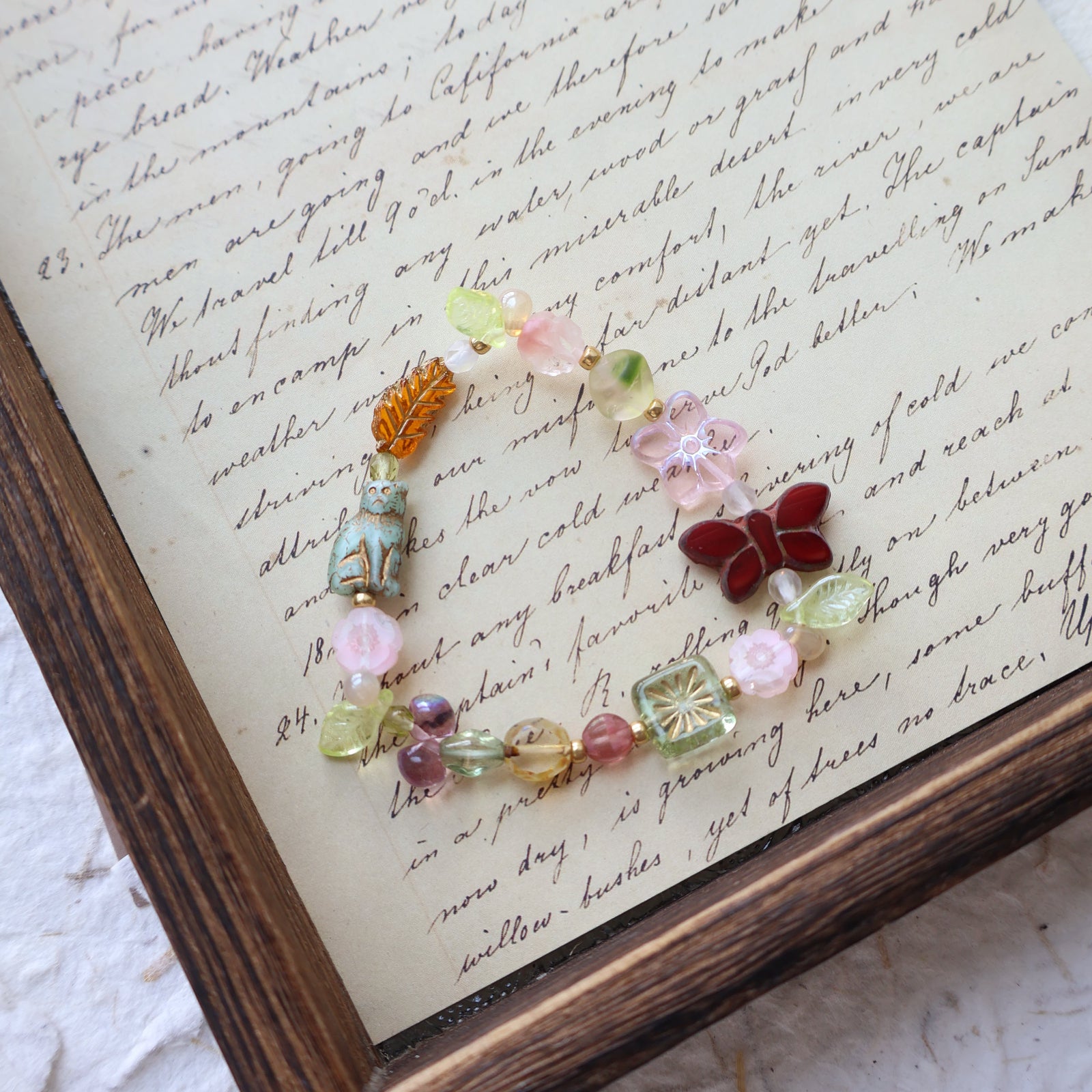 Colorful beaded bracelet on an old letter with a wooden frame