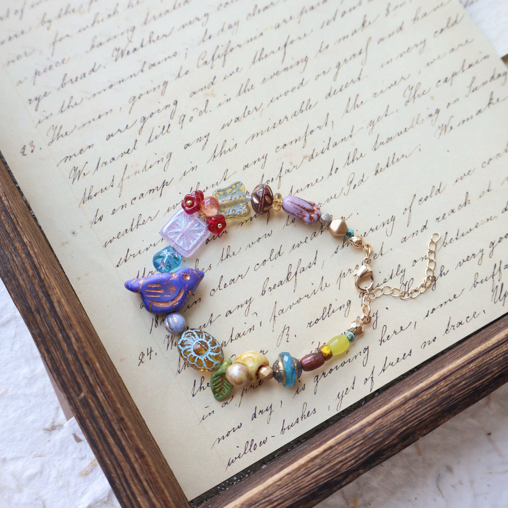 Colorful beaded necklace on a piece of paper with text