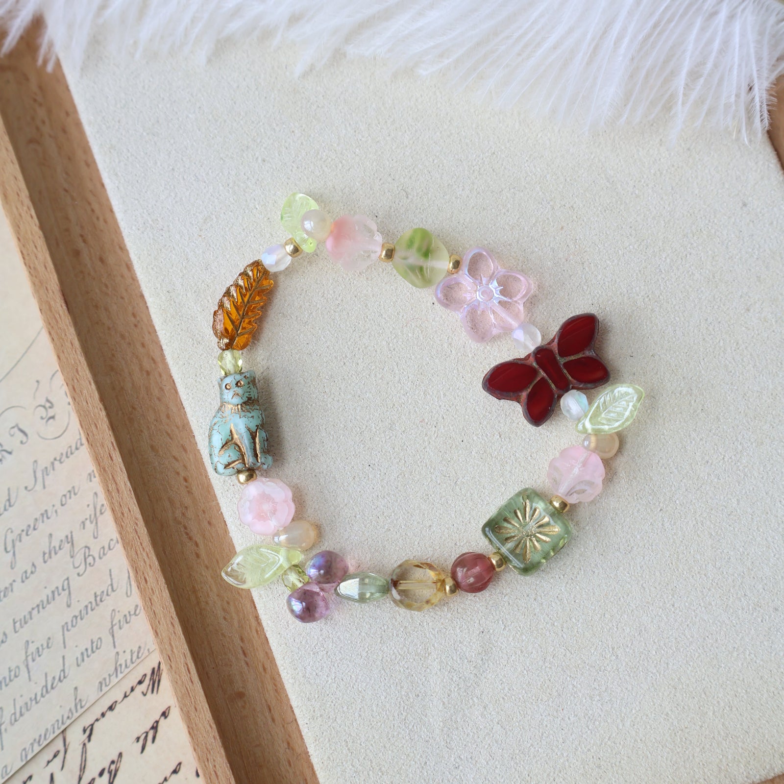 Colorful beaded bracelet with a butterfly charm on a textured surface