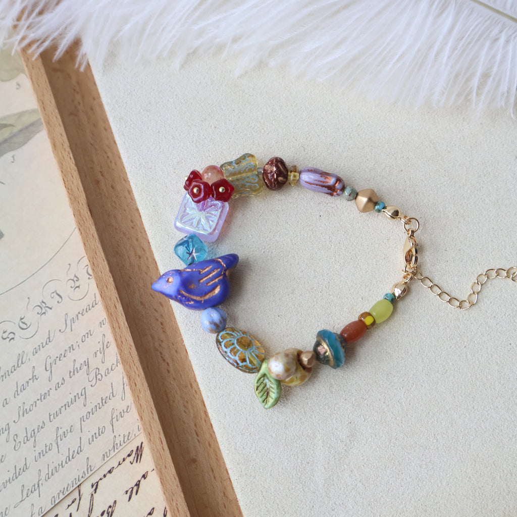 Colorful beaded bracelet with decorative charms on a textured surface