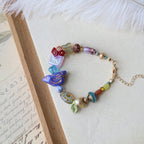 Colorful beaded bracelet with decorative charms on a textured surface