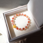 Beaded bracelet with orange and yellow beads in a white jewelry box