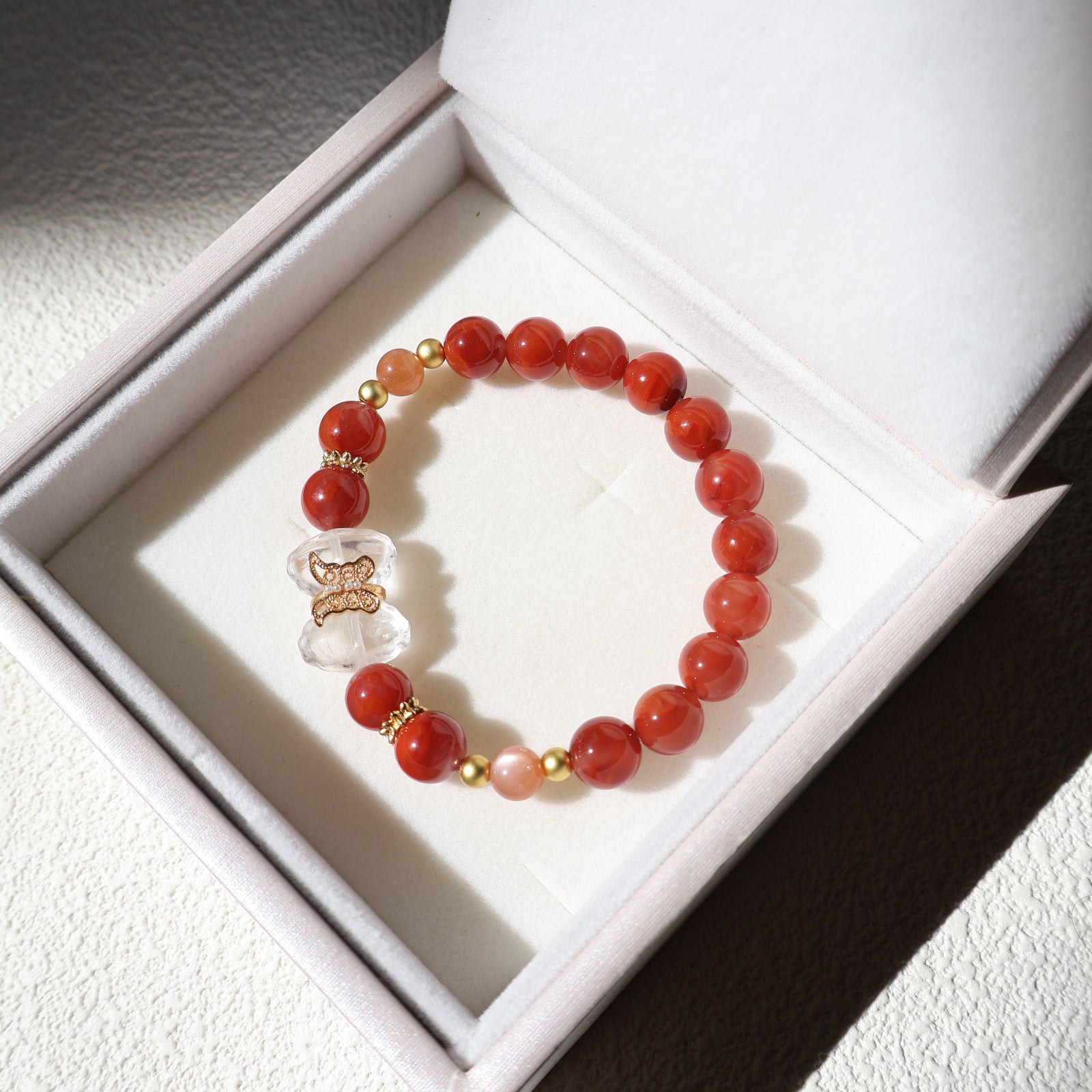Red beaded bracelet with a clear crystal charm in a white box