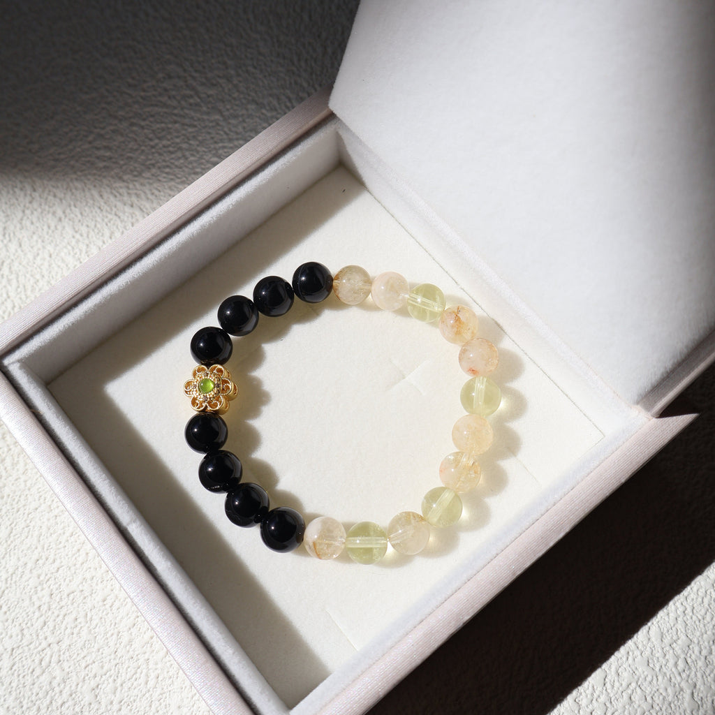 Beaded bracelet with black and multicolored beads in a white box