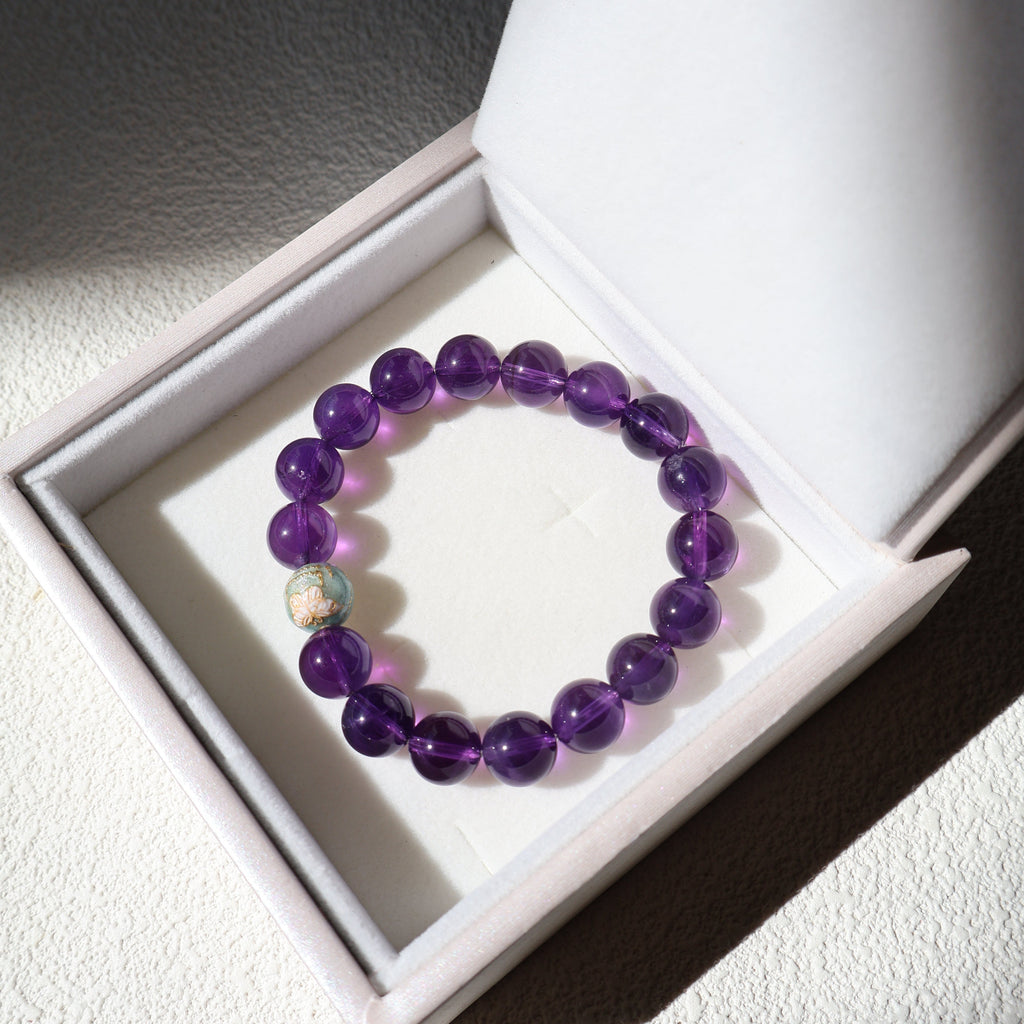 Purple beaded bracelet in a white box on a light background