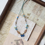 Necklace with blue and brown beads on a textured surface