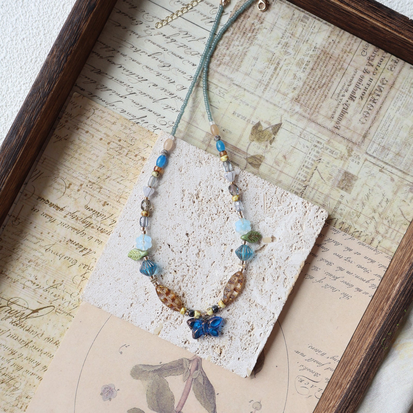 Necklace with blue and brown beads on a textured surface