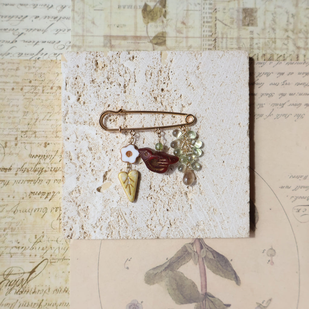 Decorative brooch with stones on a textured surface with vintage-style paper background
