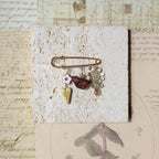 Decorative brooch with stones on a textured surface with vintage-style paper background