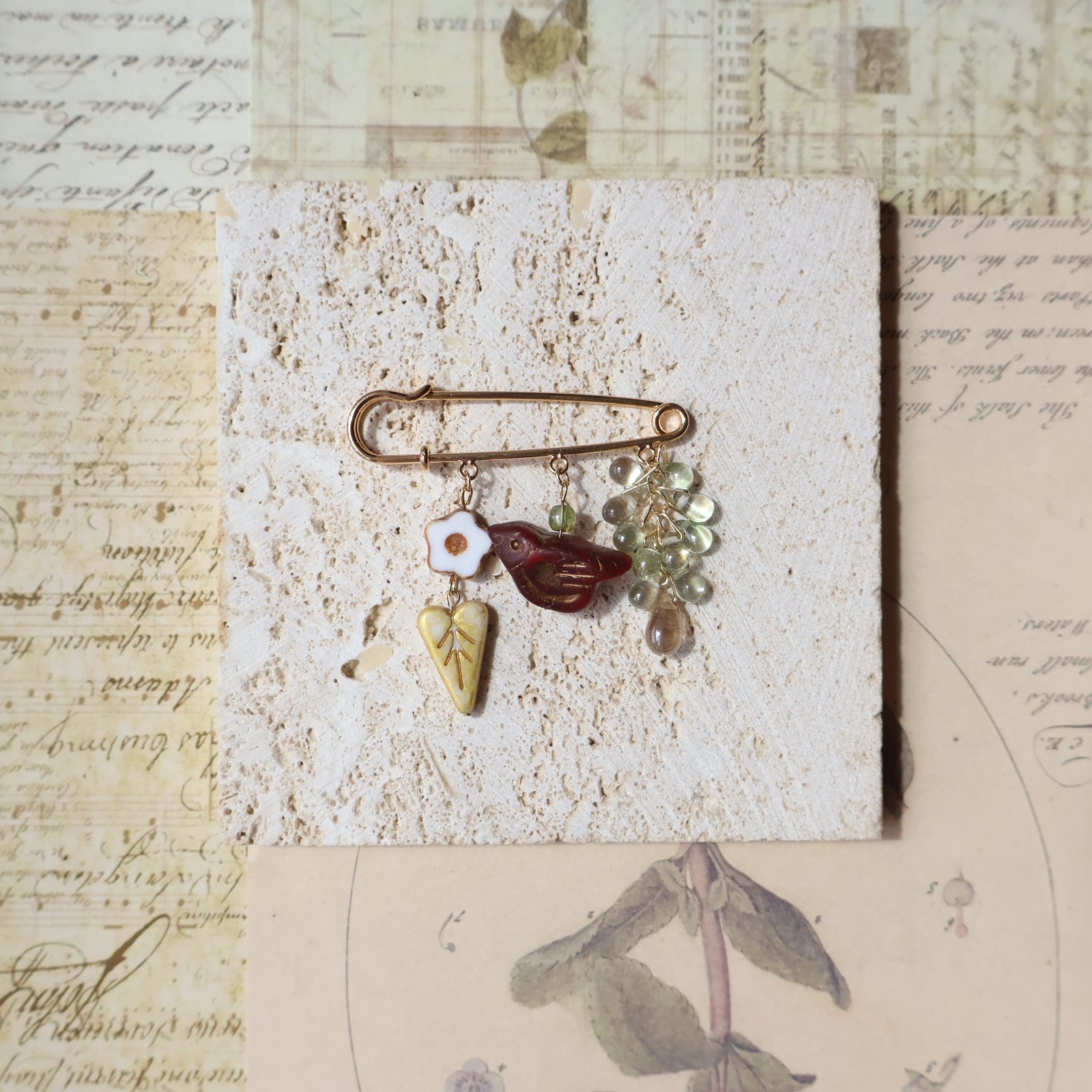 Decorative brooch with stones on a textured surface with vintage-style paper background