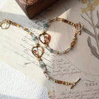 Bracelet with gold and silver beads on an old letter with floral illustrations